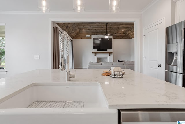 3040 Iris Dr, Hoover, AL 35244 - kitchen with stainless steel refrigerator with ice dispenser, a ceiling fan, pendant lighting, light stone counters, and ornamental molding