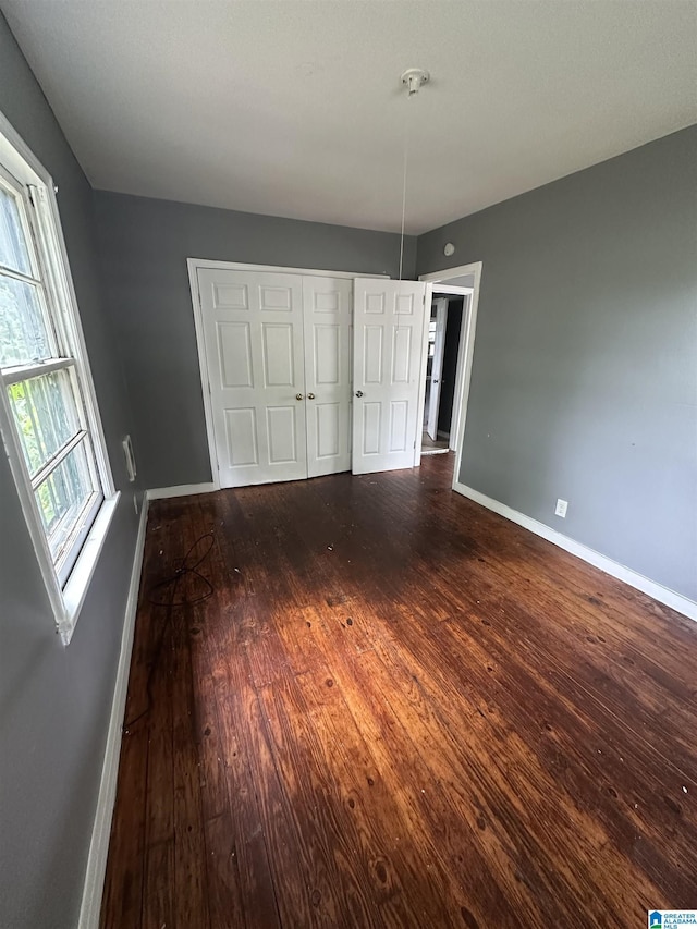 118 3rd Ave SW, Birmingham, AL 35211 - unfurnished bedroom with baseboards, wood finished floors, and a closet