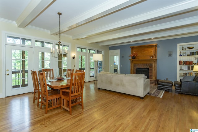 307 N Lake Rd, Hoover, AL 35242 - dining area with beam ceiling, a fireplace, light wood finished floors, a chandelier, and crown molding