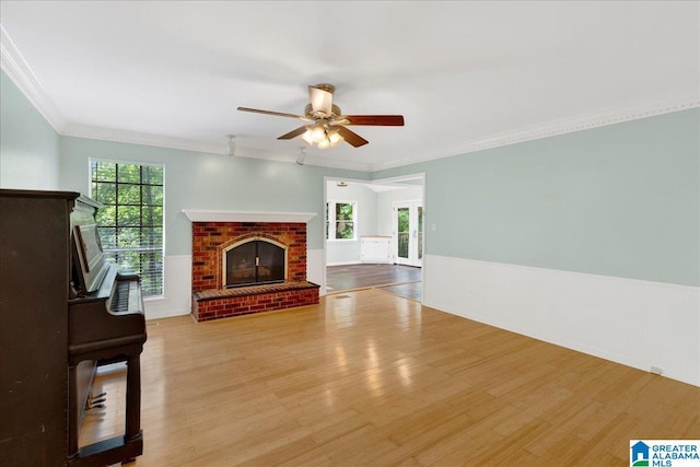 1361 Dearing Downs Cir, Helena, AL 35080 - unfurnished living room featuring wood finished floors, a fireplace, a ceiling fan, crown molding, and wainscoting