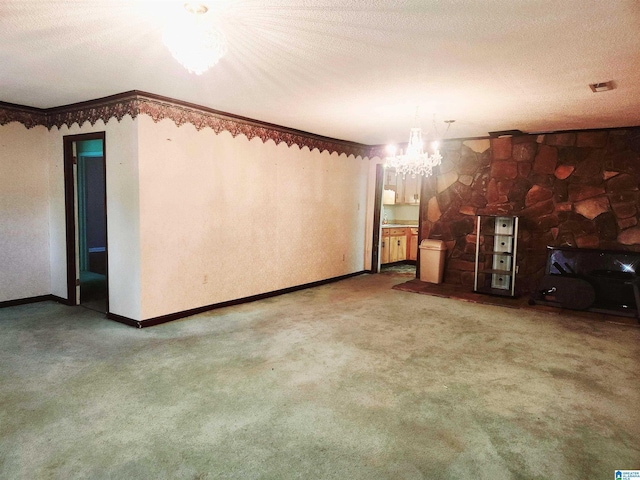 5810 Stemley Bridge Rd, Talladega, AL 35160 - unfurnished living room featuring a chandelier, carpet, baseboards, a textured ceiling, and crown molding