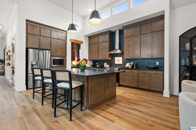1761 Gable Way, Hoover, AL 35244 - kitchen with wall chimney range hood, appliances with stainless steel finishes, dark countertops, a high ceiling, and a center island