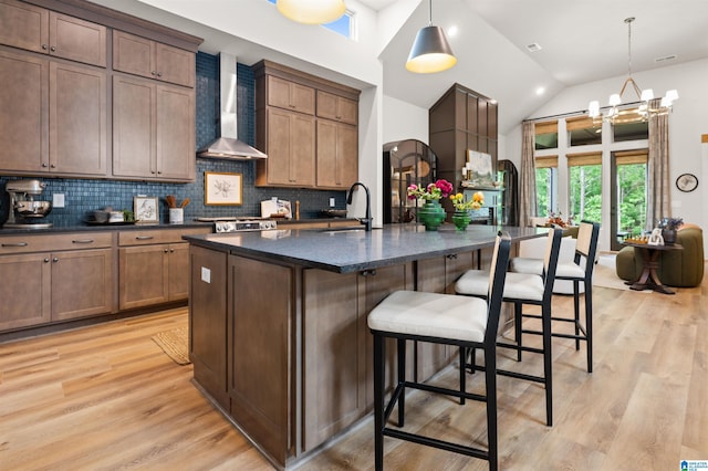1761 Gable Way, Hoover, AL 35244 - kitchen featuring wall chimney range hood, a sink, light wood finished floors, backsplash, and lofted ceiling