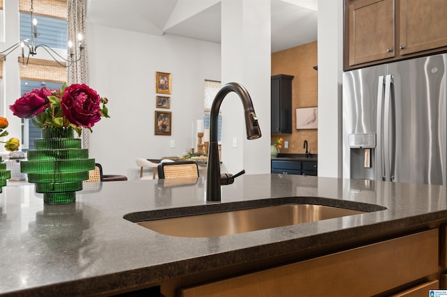 1761 Gable Way, Hoover, AL 35244 - kitchen with stainless steel fridge, a sink, dark stone counters, and a chandelier