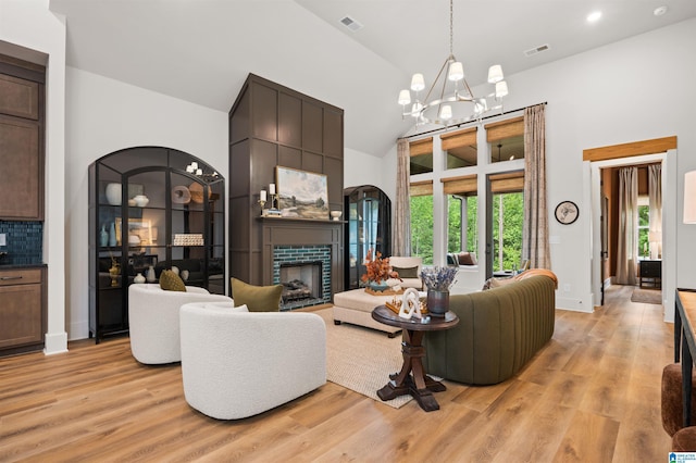 1761 Gable Way, Hoover, AL 35244 - living area with high vaulted ceiling, a tiled fireplace, light wood-style floors, a chandelier, and baseboards