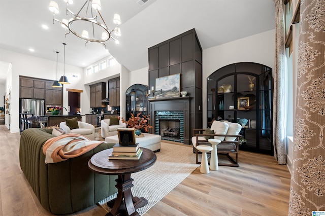 1761 Gable Way, Hoover, AL 35244 - living room featuring light wood-style flooring, a high ceiling, a chandelier, and a large fireplace