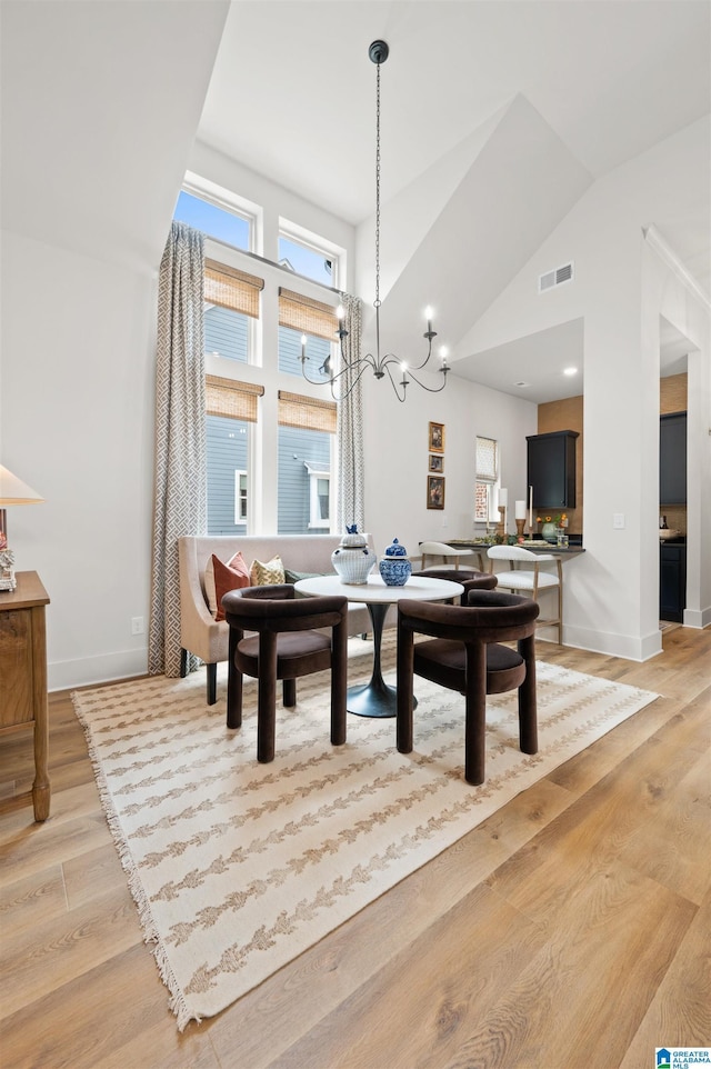 1761 Gable Way, Hoover, AL 35244 - dining space featuring light wood-style floors, baseboards, high vaulted ceiling, and a chandelier
