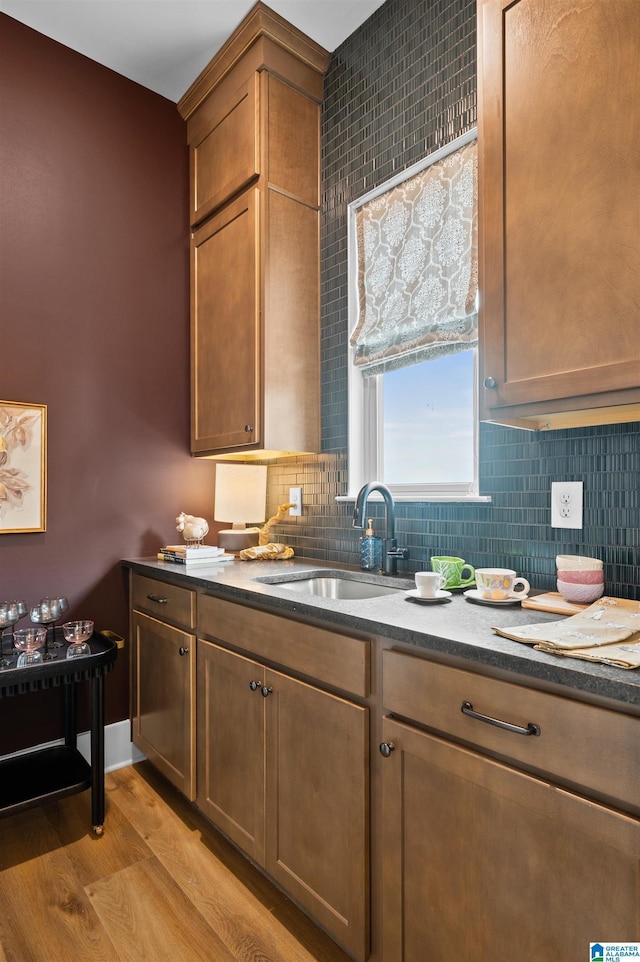 1761 Gable Way, Hoover, AL 35244 - kitchen featuring a sink, light wood-style flooring, tasteful backsplash, dark stone countertops, and brown cabinets