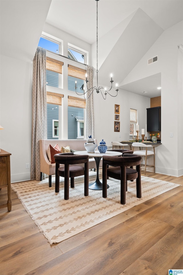 1761 Gable Way, Hoover, AL 35244 - dining space with high vaulted ceiling, light wood-style flooring, a chandelier, and baseboards