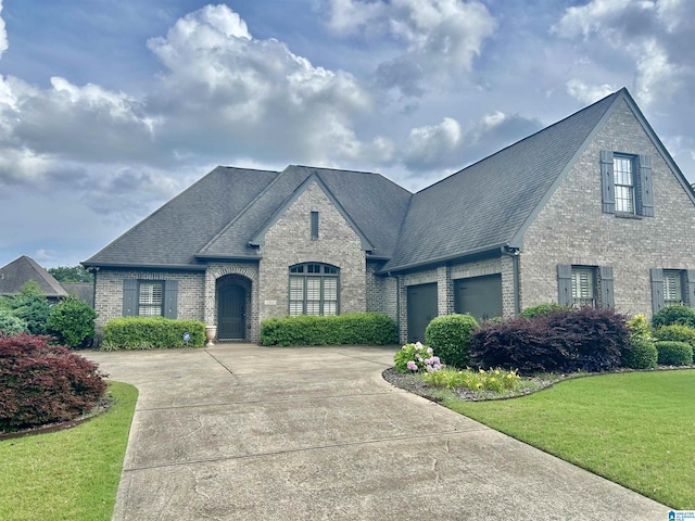 1343 Chapel St, Hoover, AL 35226 - french country inspired facade with brick siding, concrete driveway, a front yard, a garage, and a shingled roof