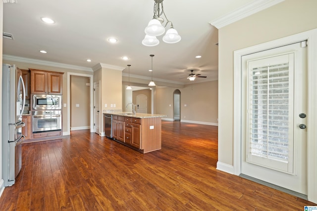 1343 Chapel St, Hoover, AL 35226 - kitchen featuring appliances with stainless steel finishes, a sink, arched walkways, brown cabinets, and crown molding