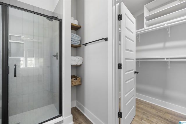 350 Shiloh Creek Dr, Calera, AL 35040 - full bath featuring a spacious closet, a stall shower, baseboards, and wood finished floors