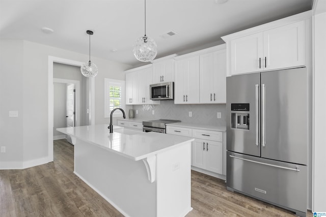 350 Shiloh Creek Dr, Calera, AL 35040 - kitchen featuring stainless steel appliances, a sink, an island with sink, wood finished floors, and white cabinets