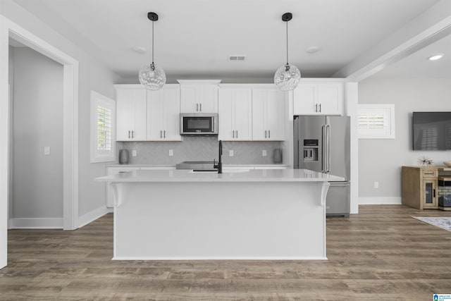 350 Shiloh Creek Dr, Calera, AL 35040 - kitchen featuring appliances with stainless steel finishes, a kitchen island with sink, white cabinets, light countertops, and tasteful backsplash