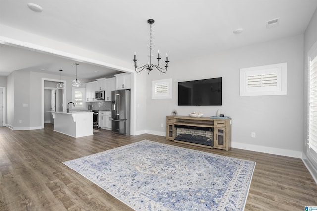 350 Shiloh Creek Dr, Calera, AL 35040 - living area with a chandelier, baseboards, dark wood-type flooring, and a fireplace