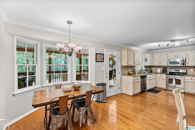 545 Russet Bend Dr, Hoover, AL 35244 - kitchen featuring appliances with stainless steel finishes, a chandelier, decorative backsplash, light wood-style floors, and ornamental molding