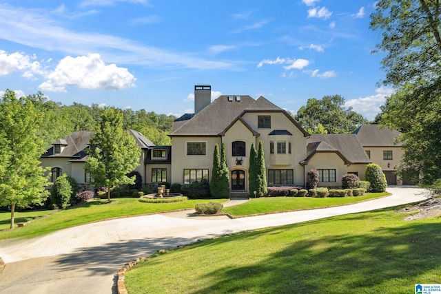 2821 Shook Hill Cir, Mountain Brook, AL 35223 - french provincial home with a chimney, stucco siding, a front lawn, and curved driveway