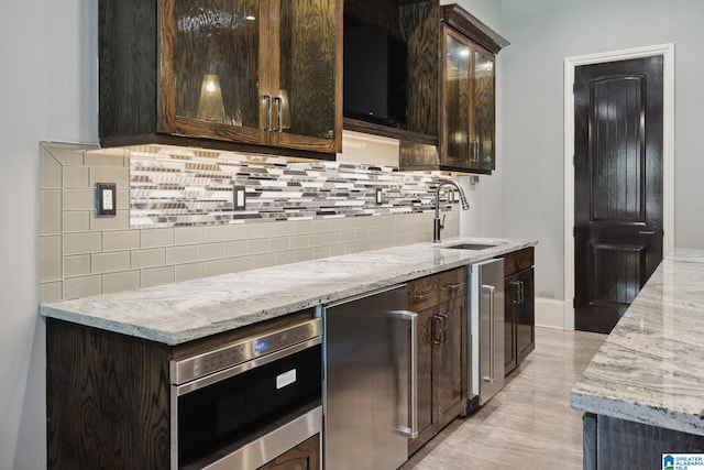 2821 Shook Hill Cir, Mountain Brook, AL 35223 - kitchen featuring a sink, dark brown cabinetry, and light stone countertops