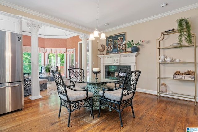 2100 Southwinds Cir, Hoover, AL 35244 - dining space featuring ornate columns, wood finished floors, a fireplace, crown molding, and baseboards