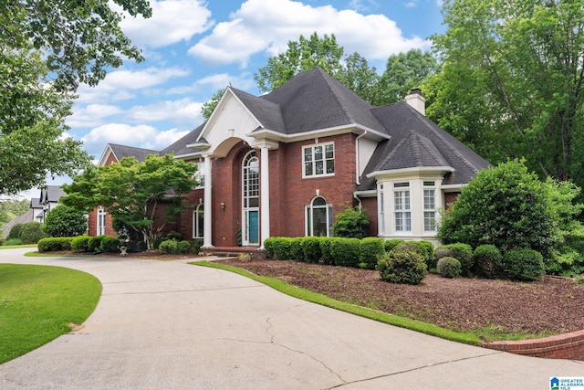 2100 Southwinds Cir, Hoover, AL 35244 - view of front facade with brick siding, driveway, a chimney, and roof with shingles