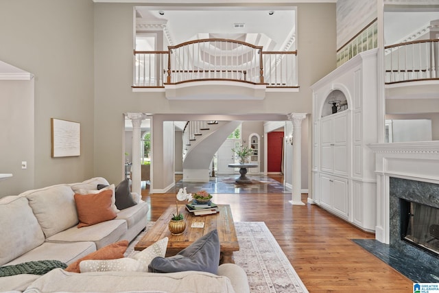2100 Southwinds Cir, Hoover, AL 35244 - living area with ornate columns, a towering ceiling, stairway, light wood-style floors, and a premium fireplace