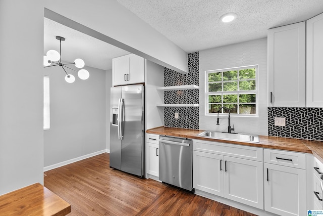 1712 34th Pl N, Birmingham, AL 35234 - kitchen with appliances with stainless steel finishes, wooden counters, a sink, open shelves, and a textured ceiling