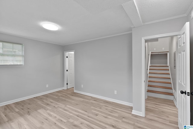 1712 34th Pl N, Birmingham, AL 35234 - unfurnished room with a textured ceiling, light wood-style floors, crown molding, stairs, and baseboards