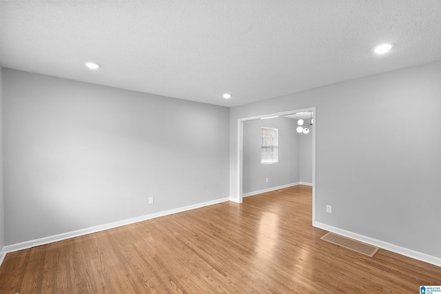 1712 34th Pl N, Birmingham, AL 35234 - unfurnished room with light wood finished floors, a chandelier, recessed lighting, baseboards, and a textured ceiling