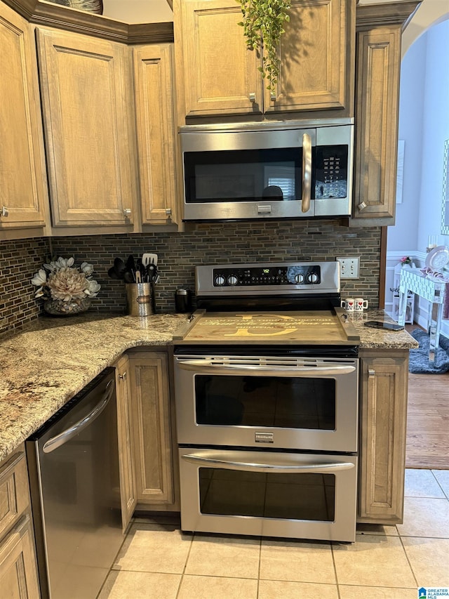 5616 Elliott Cir, Mccalla, AL 35111 - kitchen featuring appliances with stainless steel finishes, light tile patterned floors, tasteful backsplash, and light stone countertops