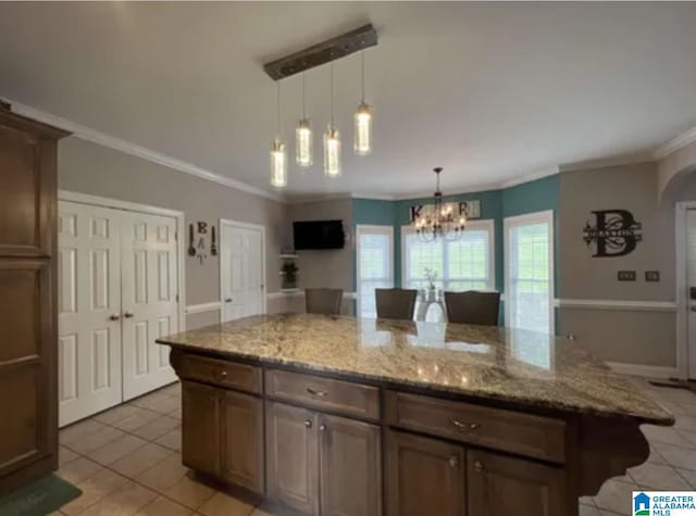 5616 Elliott Cir, Mccalla, AL 35111 - kitchen with light tile patterned floors, a chandelier, ornamental molding, light stone counters, and decorative light fixtures