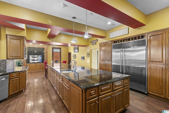 200 Asphodel Dr, Dothan, AL 36303 - kitchen with stainless steel appliances, an island with sink, dark wood finished floors, and brown cabinetry