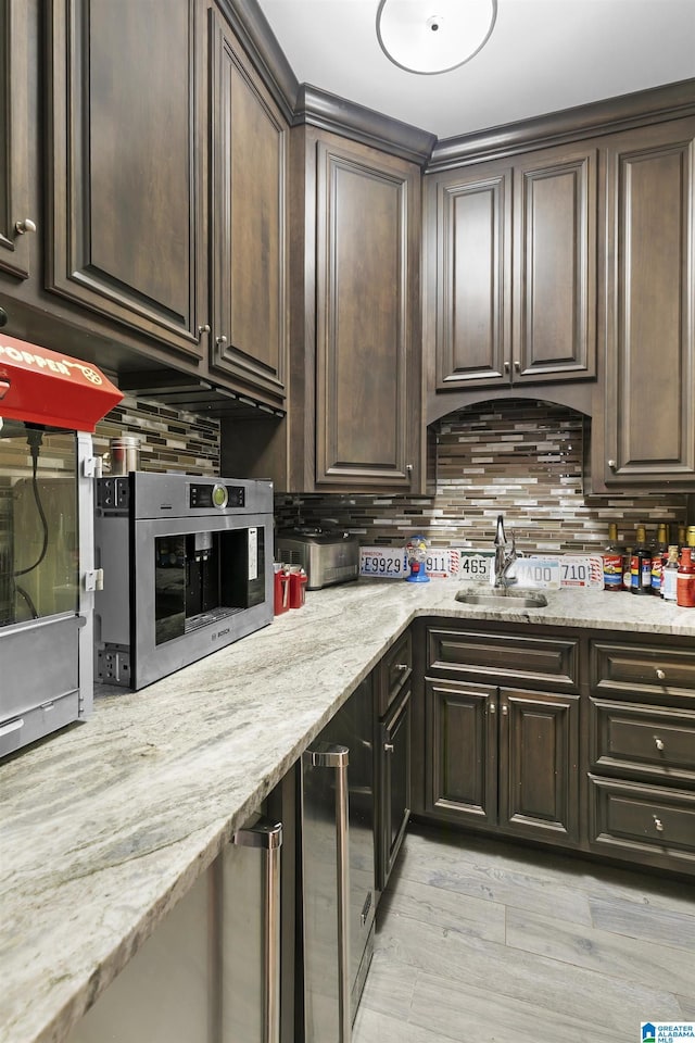 200 Asphodel Dr, Dothan, AL 36303 - kitchen featuring dark brown cabinetry, backsplash, and light stone counters