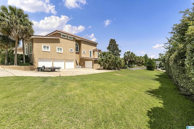 200 Asphodel Dr, Dothan, AL 36303 - rear view of property with stucco siding, driveway, a garage, and a yard