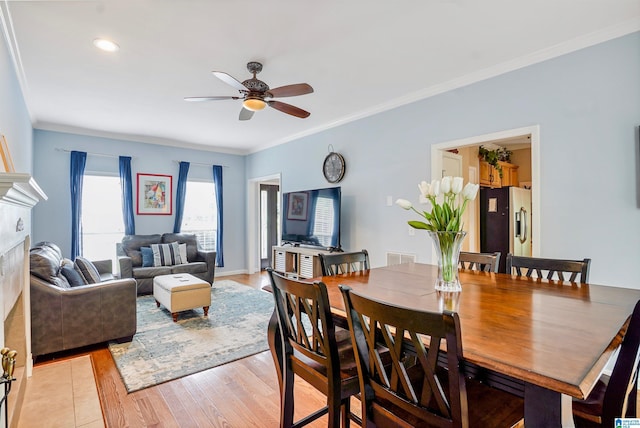 311 Hunter Hills Cir, Chelsea, AL 35043 - dining space featuring a fireplace, ceiling fan, crown molding, light wood-style flooring, and baseboards