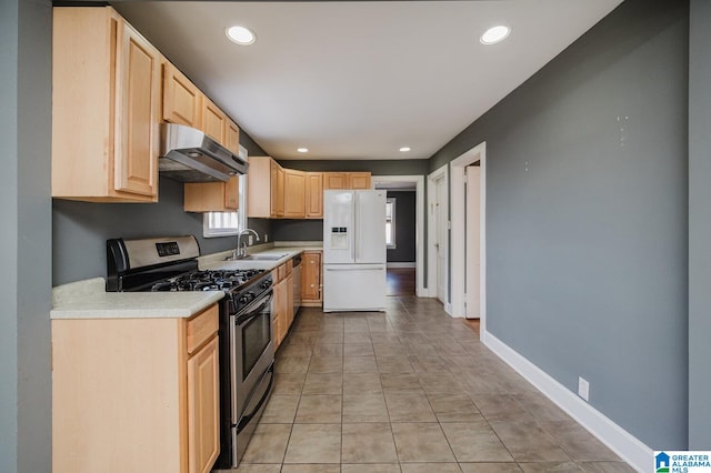 516 85th St, Birmingham, AL 35206 - kitchen featuring exhaust hood, white refrigerator with ice dispenser, stainless steel gas range oven, light brown cabinets, and a sink