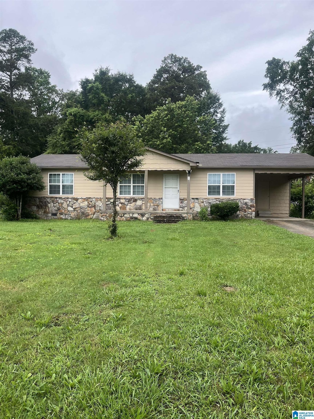 8 Fieldview Dr, Oneonta, AL 35121 - view of front facade with stone siding, an attached carport, a front lawn, and driveway