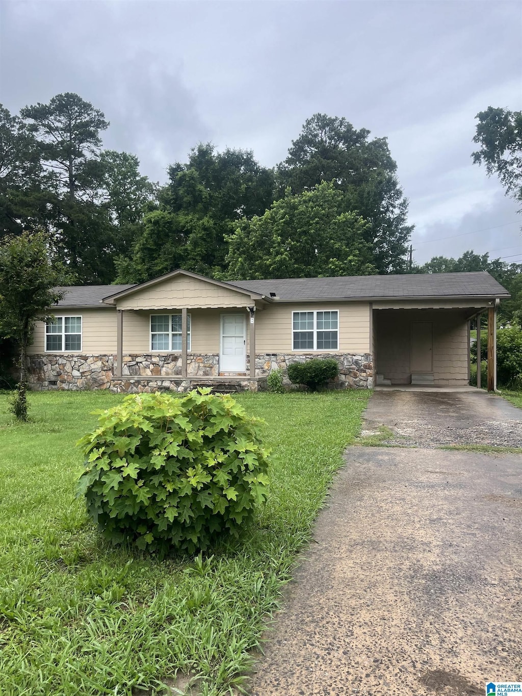 8 Fieldview Dr, Oneonta, AL 35121 - ranch-style house with stone siding, a carport, asphalt driveway, and a front lawn