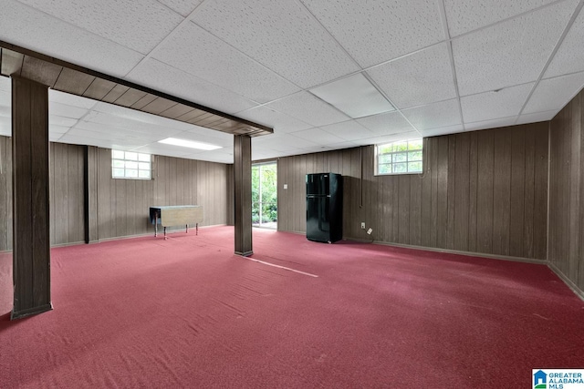 5420 Pine St, Sylvan Springs, AL 35118 - basement featuring freestanding refrigerator, wooden walls, carpet flooring, and a paneled ceiling