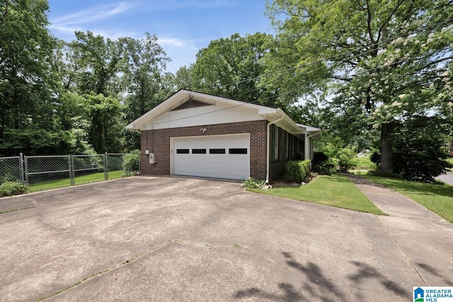 5420 Pine St, Sylvan Springs, AL 35118 - view of side of home with brick siding, concrete driveway, view of scattered trees, and an attached garage