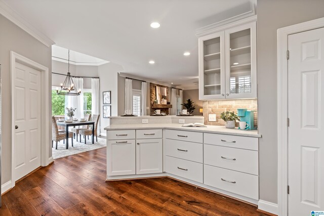 5265 Lake Crest Cir, Hoover, AL 35226 - kitchen featuring a peninsula, a chandelier, glass insert cabinets, ornamental molding, and light countertops