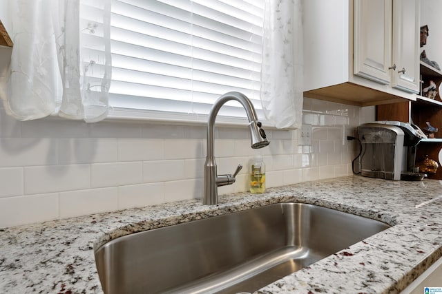 3096 Hidden Forest Cv, Montevallo, AL 35115 - kitchen view of a sink, decorative backsplash, light stone counters, and white cabinetry