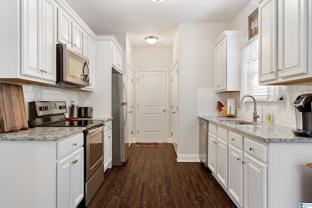 3096 Hidden Forest Cv, Montevallo, AL 35115 - kitchen with appliances with stainless steel finishes, a sink, white cabinets, dark wood-style flooring, and decorative backsplash