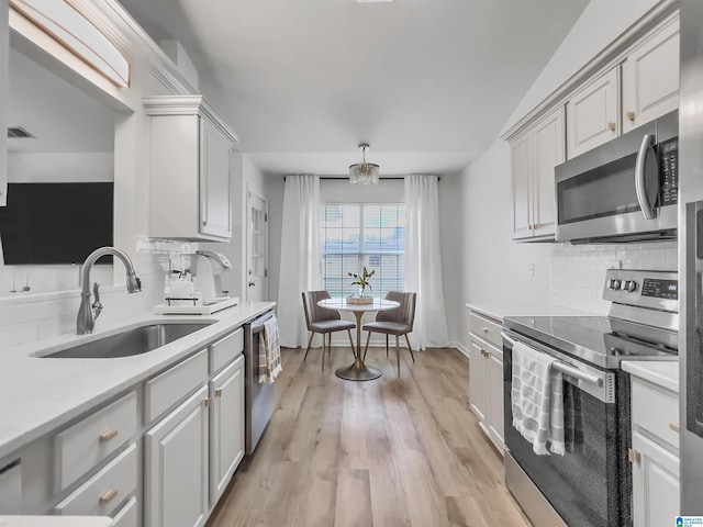 156 Brook Highland Cv, Birmingham, AL 35242 - kitchen with stainless steel appliances, a sink, backsplash, light countertops, and light wood-type flooring