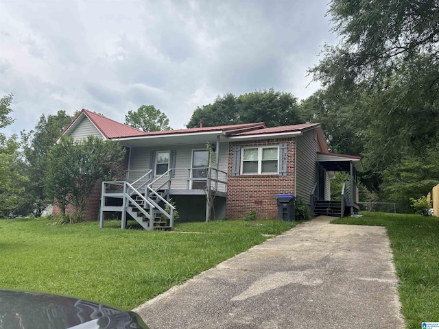 261 Ebenezer Rd, Odenville, AL 35120 - view of front facade with covered porch, a front lawn, brick siding, and concrete driveway