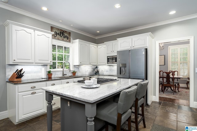 2300 Ridge Trl, Birmingham, AL 35242 - kitchen featuring a sink, appliances with stainless steel finishes, stone tile floors, white cabinets, and a breakfast bar