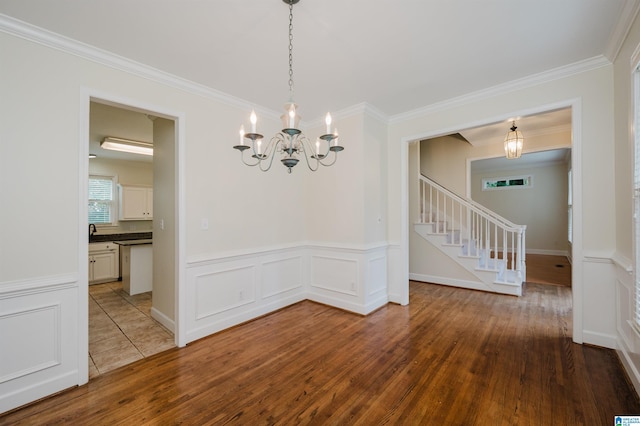 822 Boulder Ridge Cir, Hoover, AL 35244 - unfurnished dining area with a chandelier, wood finished floors, stairway, crown molding, and wainscoting