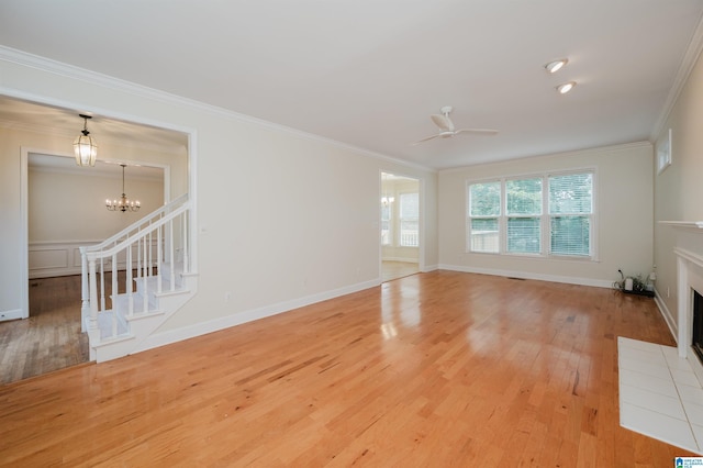 822 Boulder Ridge Cir, Hoover, AL 35244 - unfurnished living room featuring light wood-style floors, ornamental molding, a fireplace with flush hearth, ceiling fan, and a chandelier