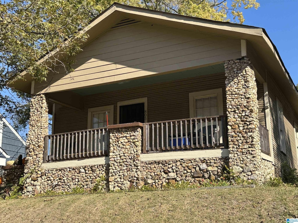 805 78th St S, Birmingham, AL 35206 - view of side of home with a porch, stone siding, and a lawn