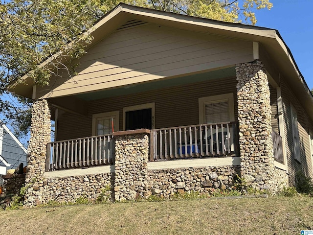 805 78th St S, Birmingham, AL 35206 - view of side of home with a porch, stone siding, and a lawn