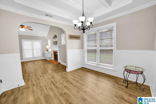 123 Whitestone Trl, Calera, AL 35040 - unfurnished dining area featuring wainscoting, crown molding, arched walkways, a fireplace with raised hearth, and a ceiling fan